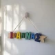 Handmade light blue Easter candle with personalized wooden name decoration and elegant embellishments